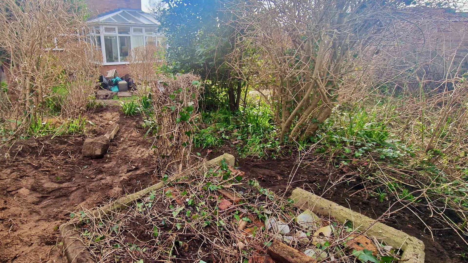 Hidden Compost Structure and Tree Stump During Garden Clearance Hidden tree stump and old concrete compost structure uncovered during garden clearance at our Surrey family home.