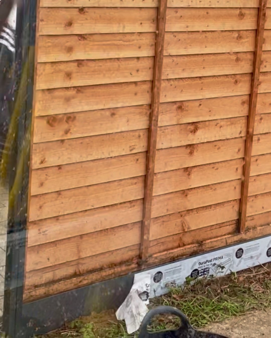 DuraPost PRIMA anthracite grey composite gravel board used at the base of a garden fence panel.