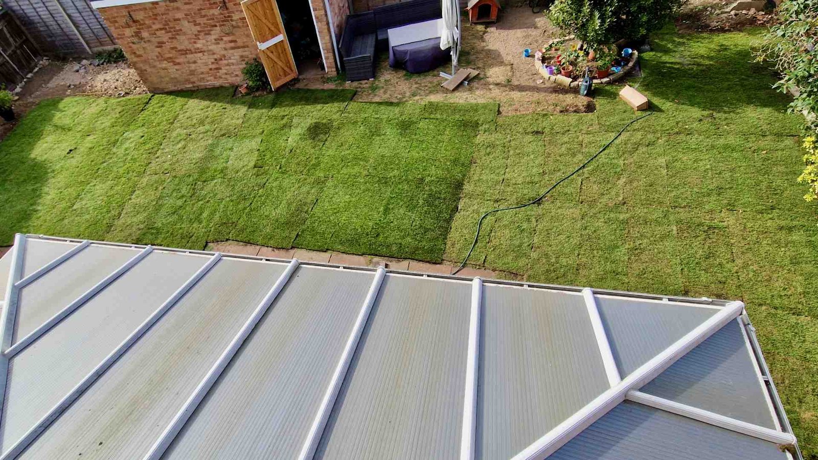 Aerial view showing the new lawn almost completely laid across the Surrey garden.