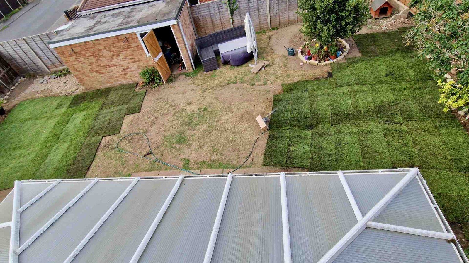 Drone photograph showing the garden halfway through laying fresh turf.