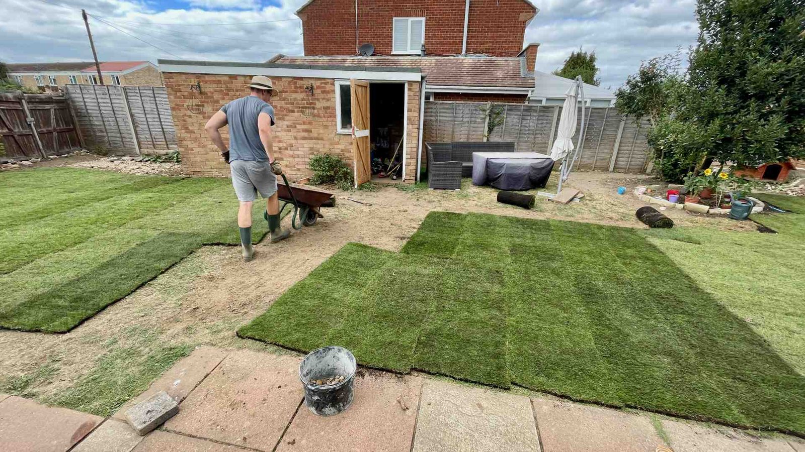 Laying Fresh Turf in Our Surrey Family Garden Superman laying fresh turf across the newly prepared family garden in Surrey.