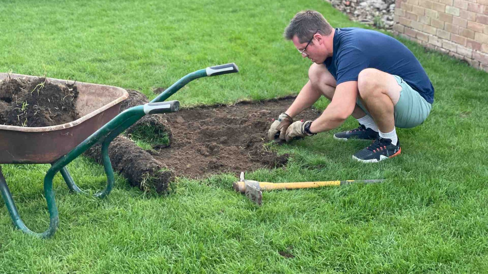 Fine Tuning the Finish Superman lifting sections of the newly laid lawn to remove old grass beneath and level the ground in our Surrey garden.