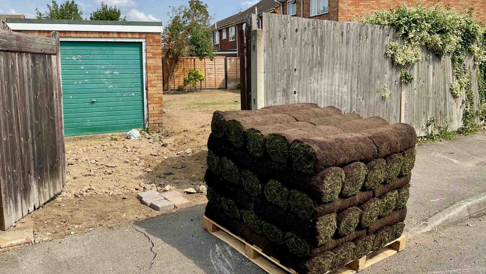 Fresh Turf Arrives for Our Surrey Garden Transformation A pallet of fresh turf delivered outside our Surrey home, ready to transform the newly prepared back garden into a family lawn.